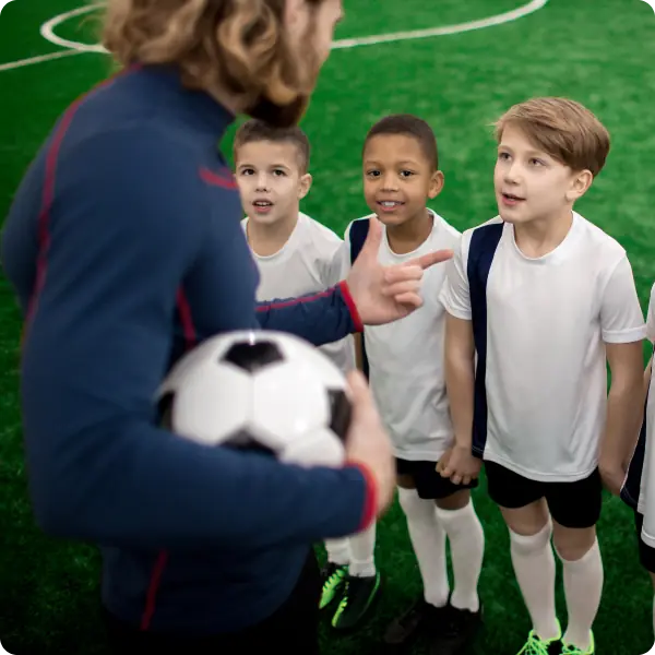 Coach connecting with young athletes before practice